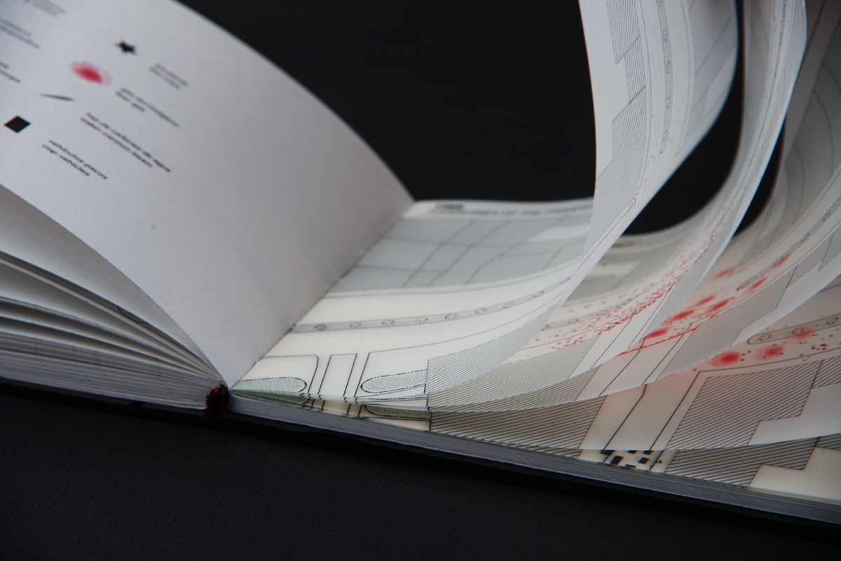 A book with pages spread open, showing translucent paper with red markings and intricate patterns.